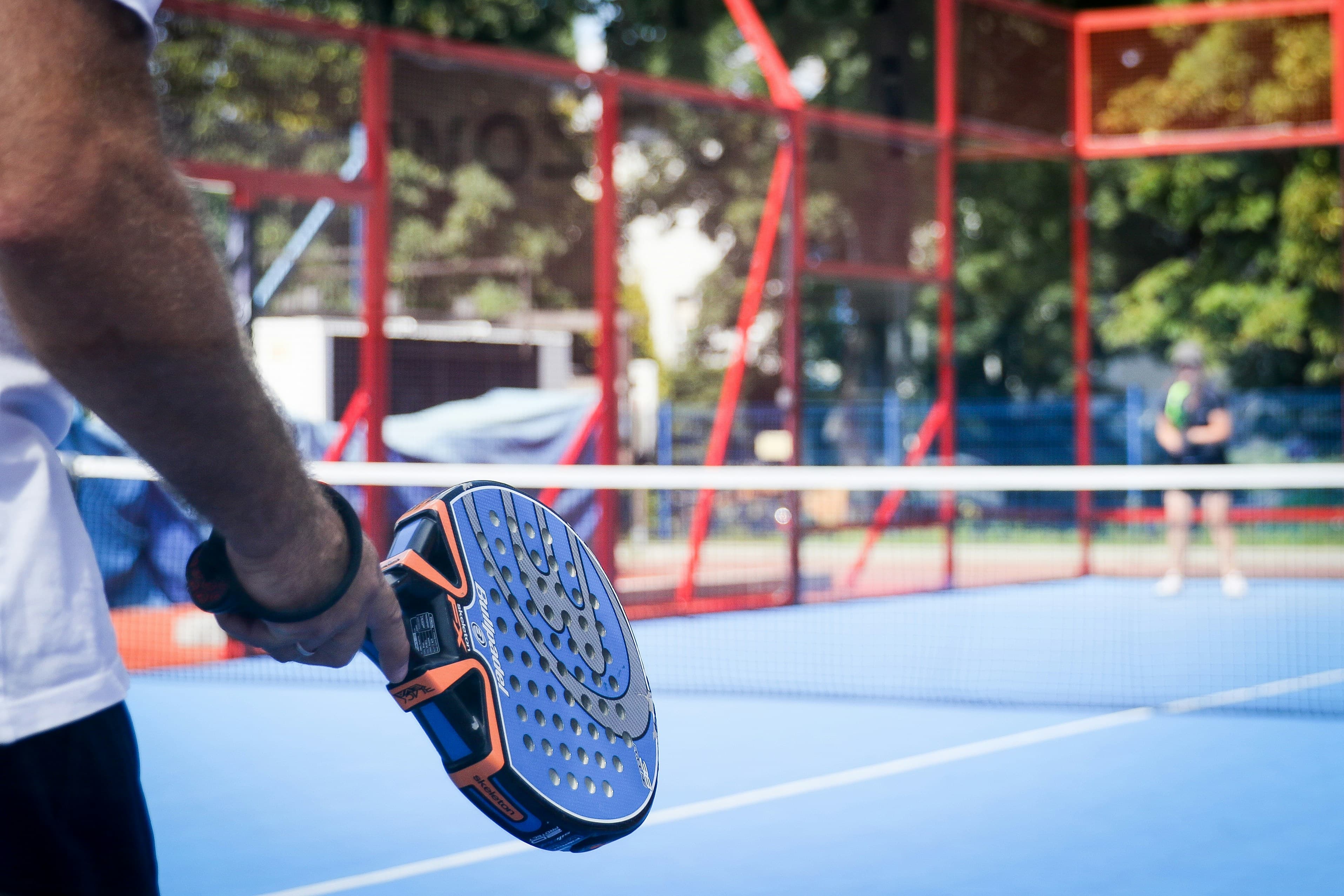 Padel players meeting on an outdoor court.